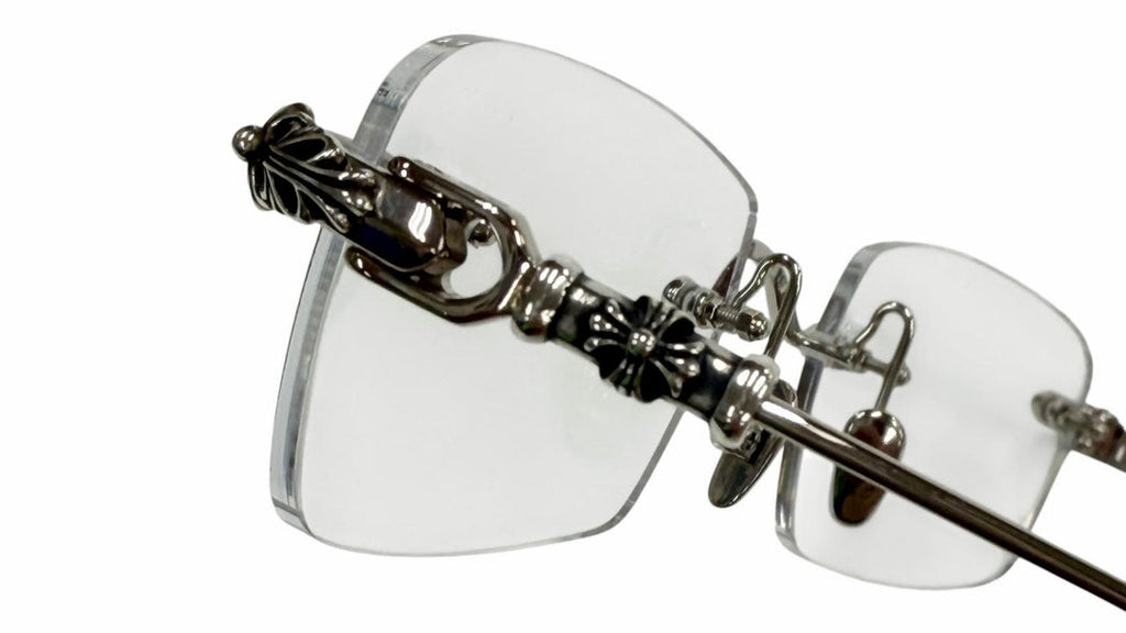 Clear eyeglasses with decorative metal frame on a white background