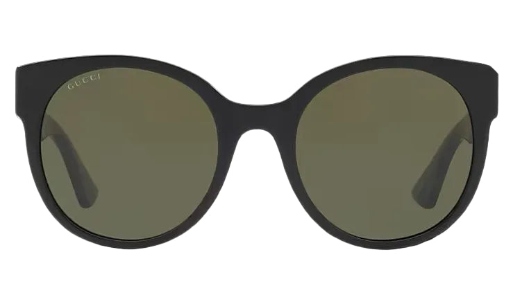 Sunglasses with dark frames and green lenses on a black background