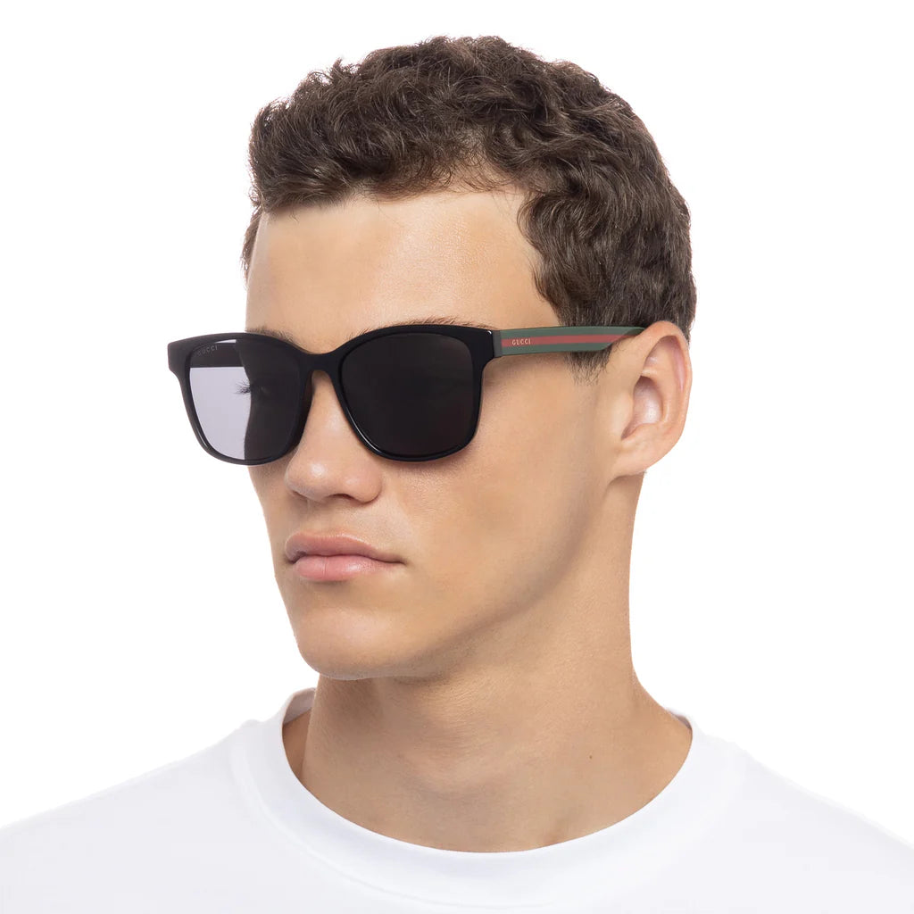 Person wearing black sunglasses with a white background